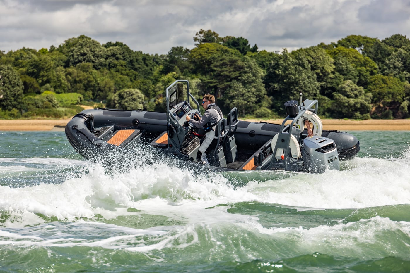 RIB powerboat turning at planing speed throwing spray on the Solent