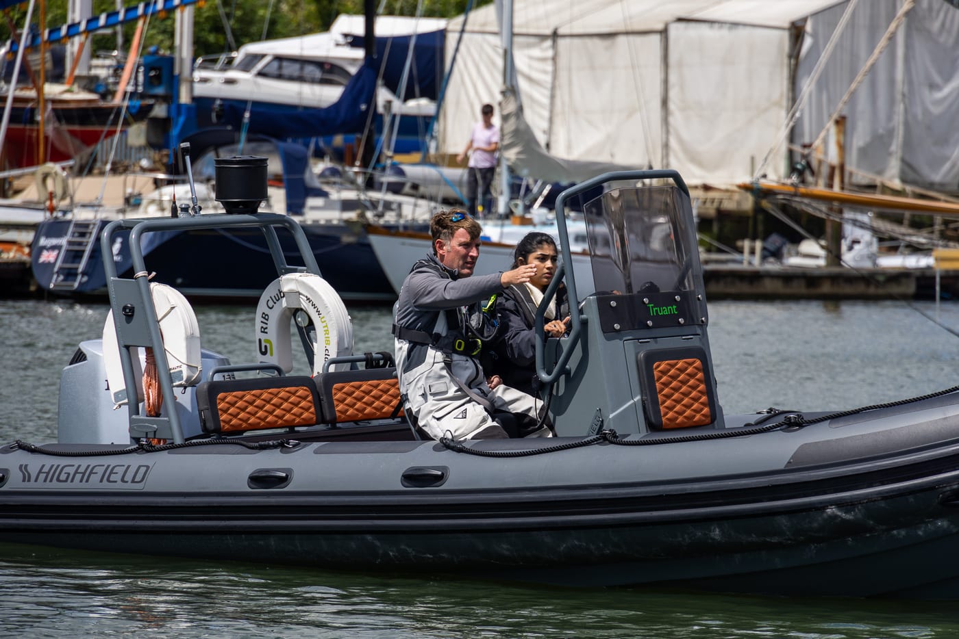 RYA instructor coaching a student at the helm of a Highfield RIB at Hamble Point Marina